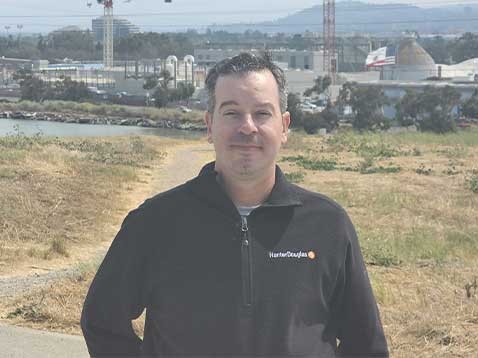 A man posing for a photo out in a field