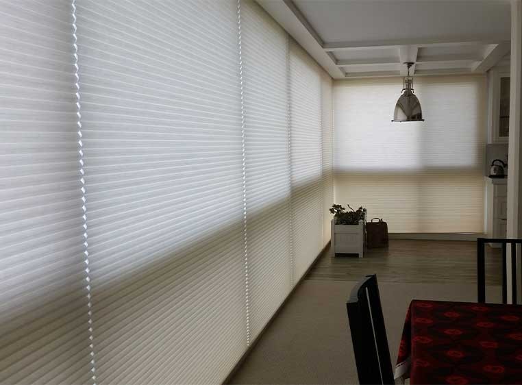 Close-up shot of honeycomb shades on a wall of windows